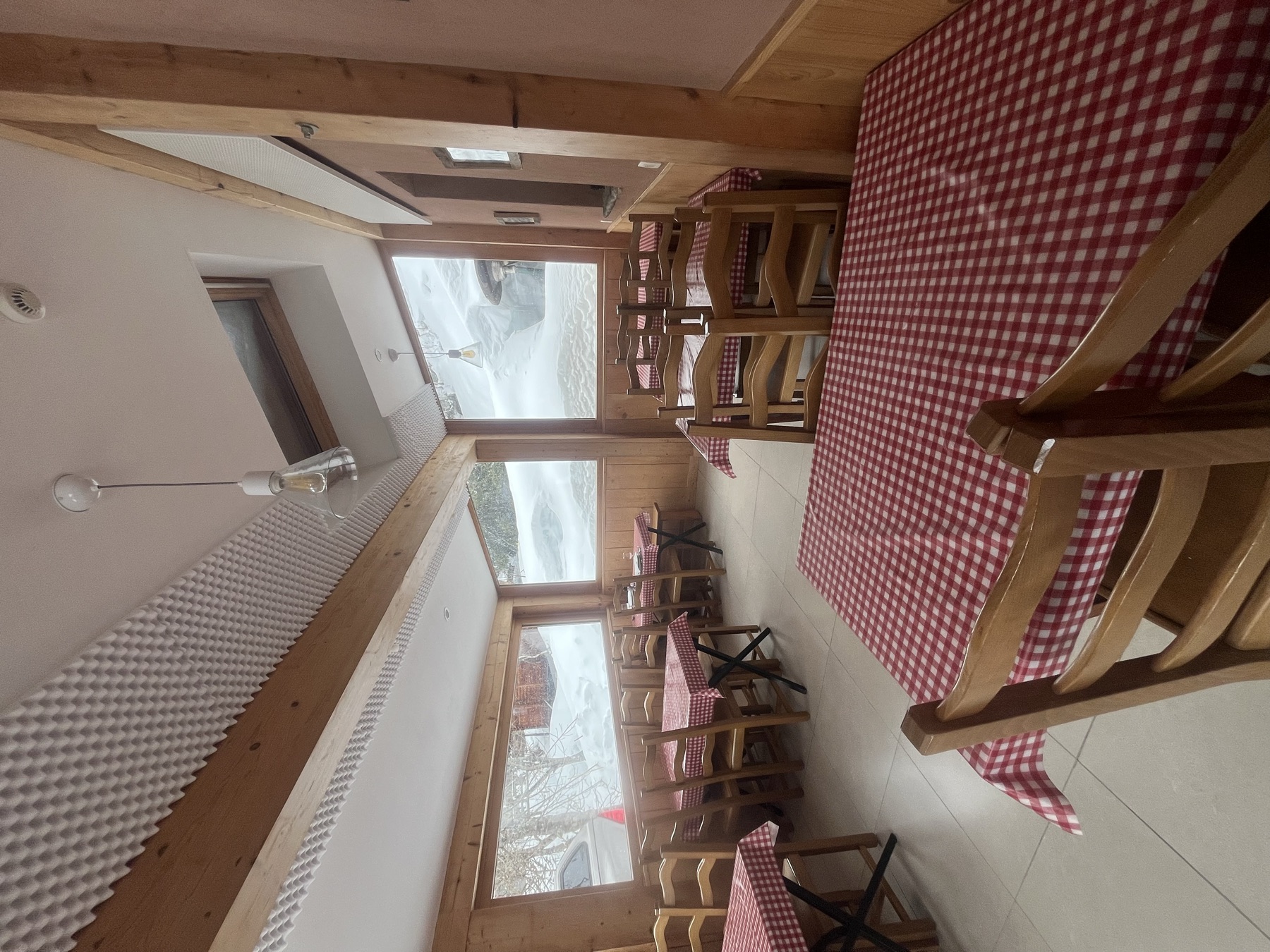 Bright dining room with red gingham tablecloths and large windows
